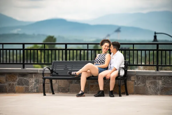 Two women sit on a park bench. 