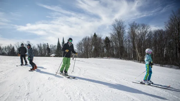 A family skiing at Titus Mountain.