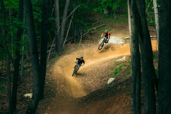 Two mountain bikers coming down a berm