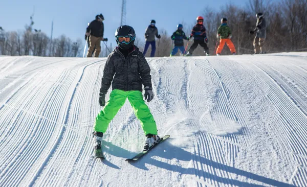 A young kid skiing down the slope at Mt Pisgah