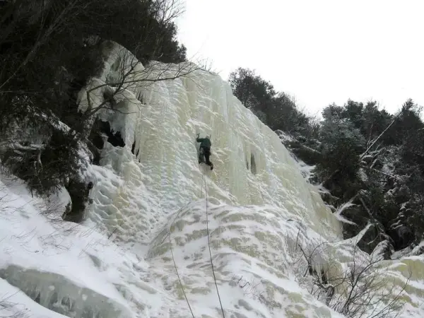 An ice climber leading up a headwall.