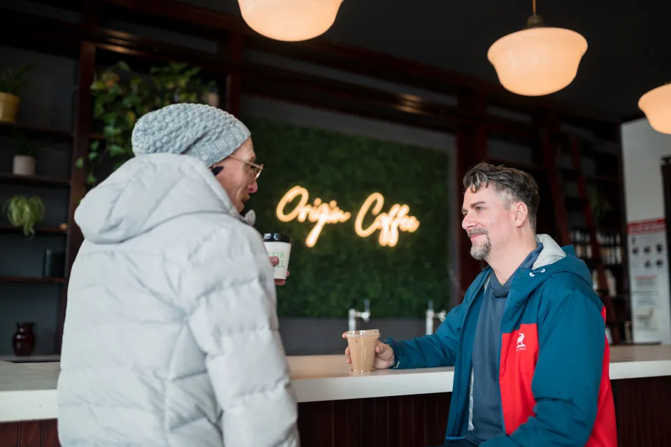 two men sit at a coffee bar at Origin Coffee