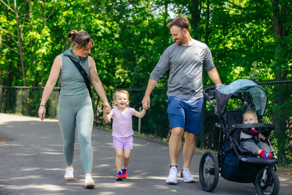 A man and woman walk their two kids on a path.