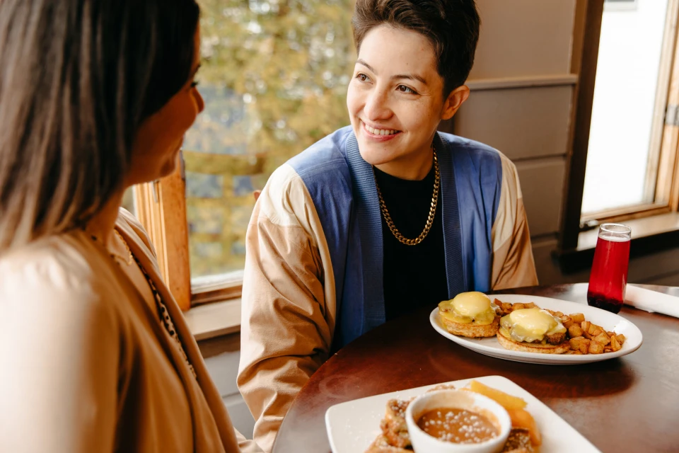 Two people look at each other over breakfast