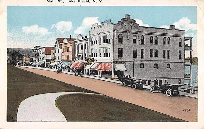 A vintage postcard showing a colorized photo illustration of Lake Placid's downtown.