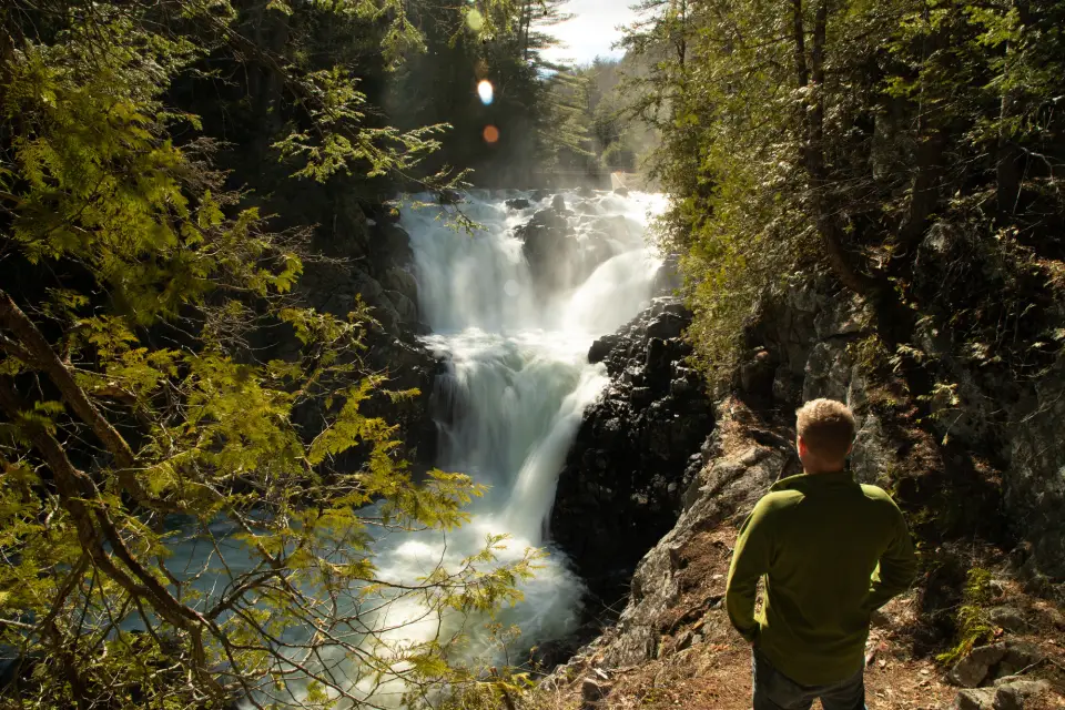 A hiker looking at a waterfall.