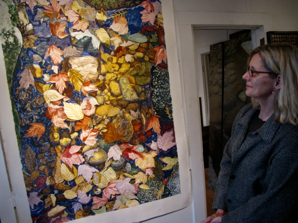 A woman looking at an art piece in a Lake Placid art gallery.