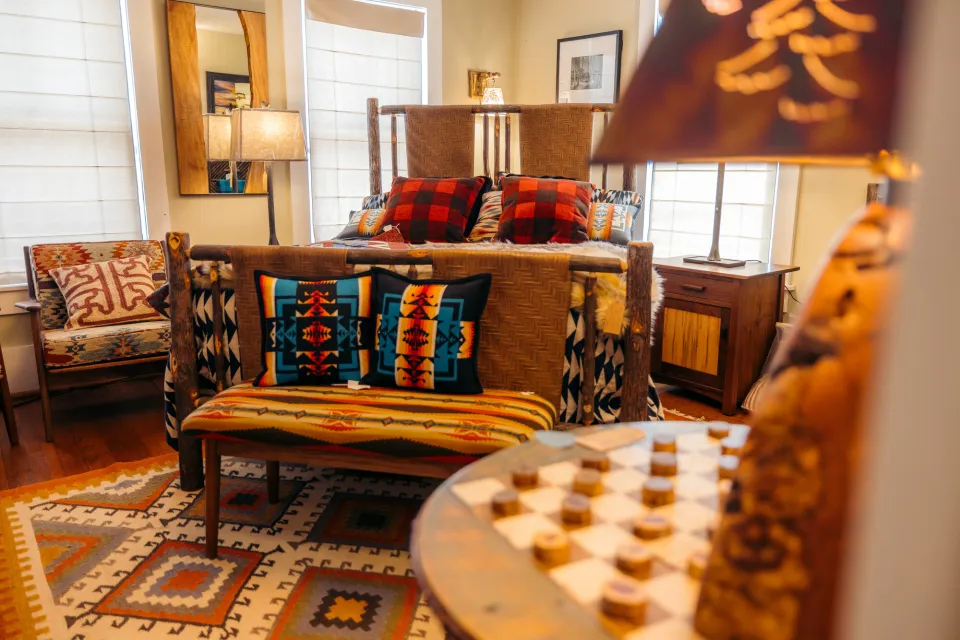 A store display of Adirondack crafted and inspired furniture, including a log bed, indigenous-inspired blankets and rugs, and Adirondack art.