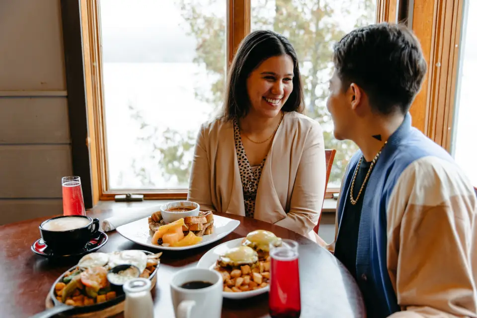 Two women enjoy brunch at a lakeside restaurant.