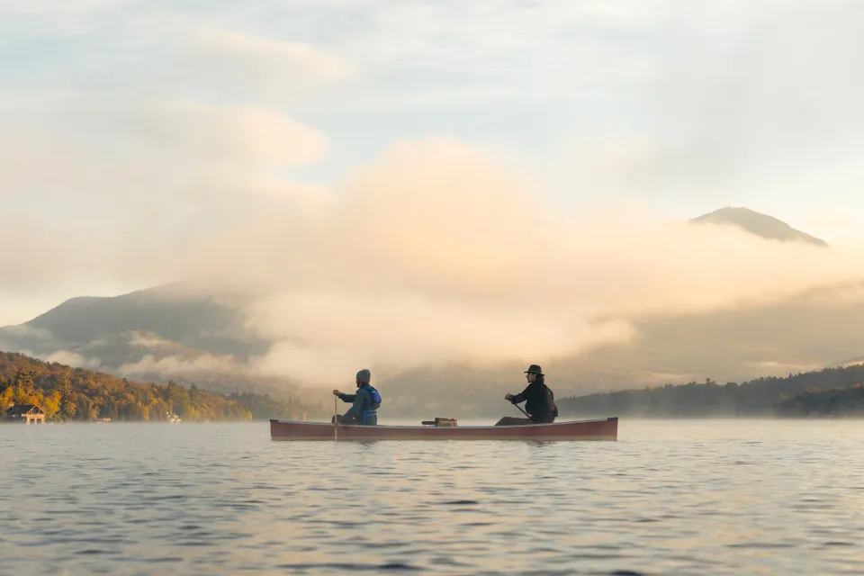 Two people paddling a canoe on Lake Placid.