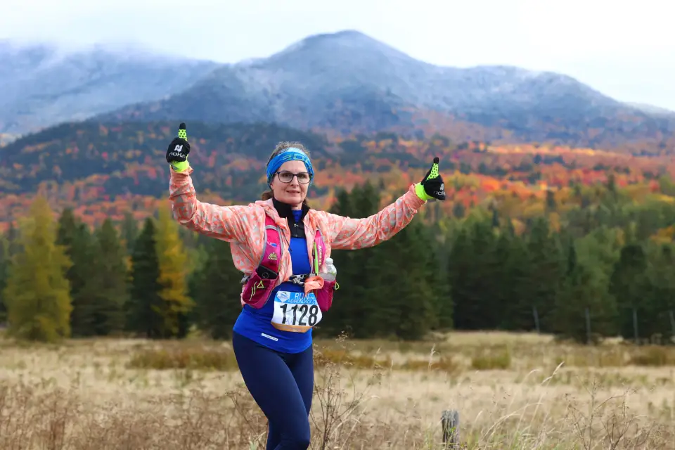 A woman running in the Lake Placid Classic Half Marathon during the fall.