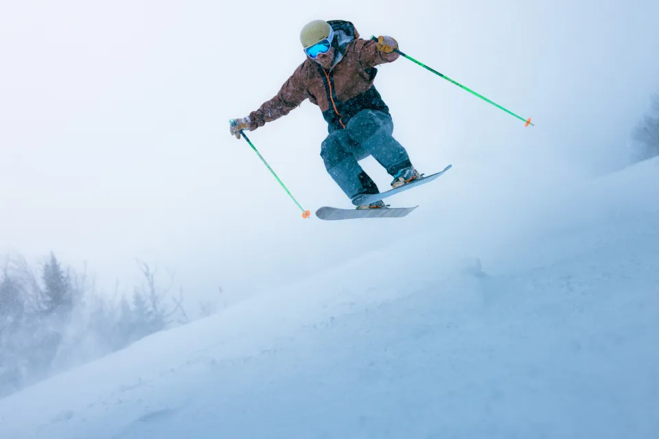Skier jumps in powdery snow on ski slope