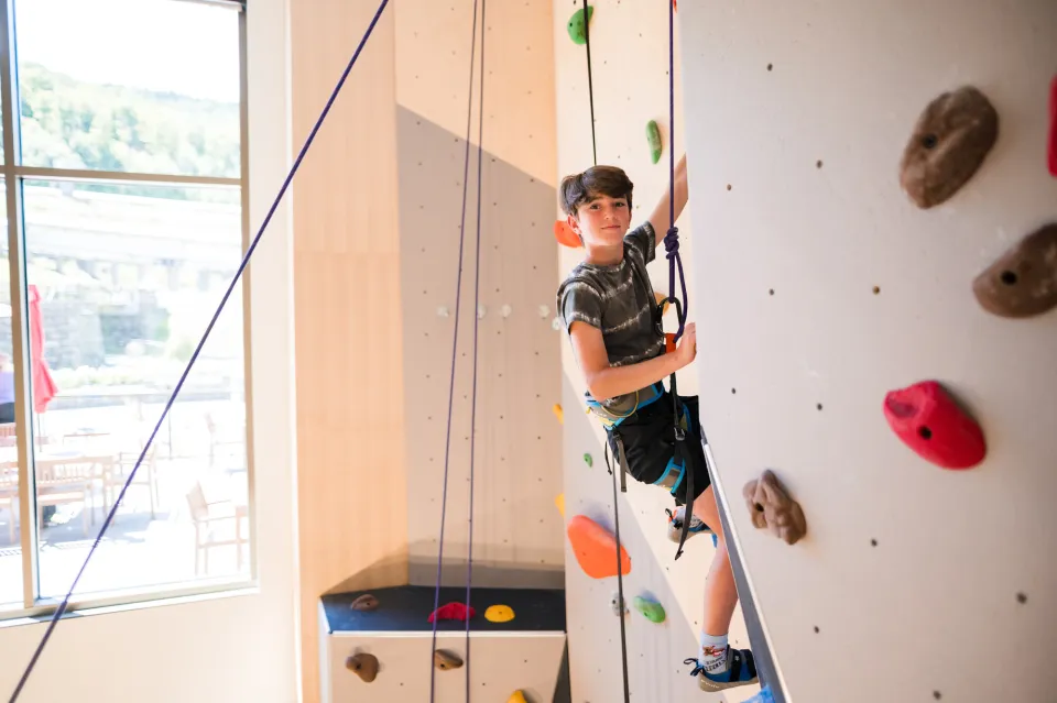 A child climbing at indoor climbing gym.
