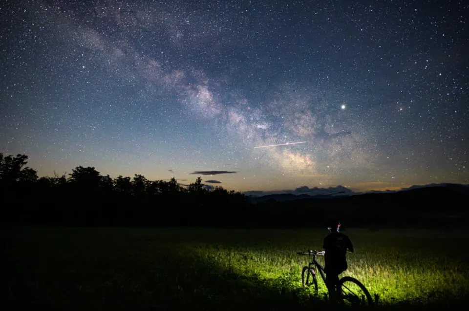 A mountain biker with a headlamp at night