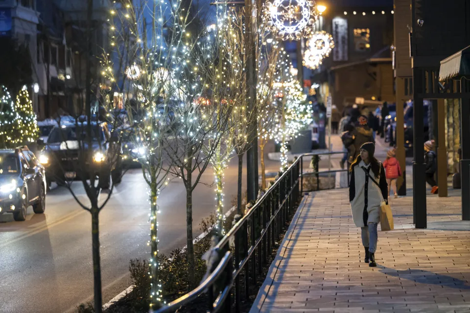 A woman walks main street at night. 