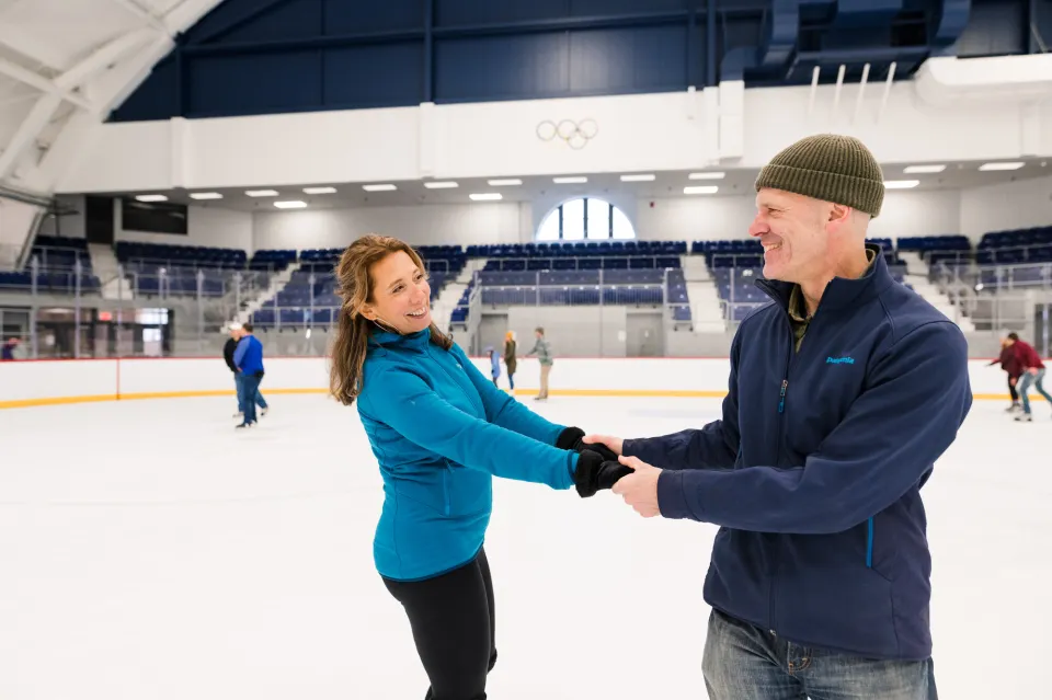 A man and woman ice skate together.