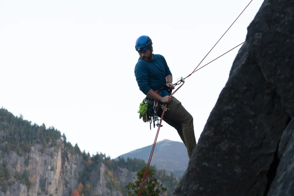 A climber rappelling down a cliff