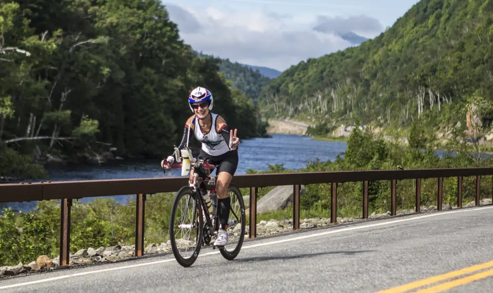 An Ironman athlete rides her bike past the Cascade Lakes