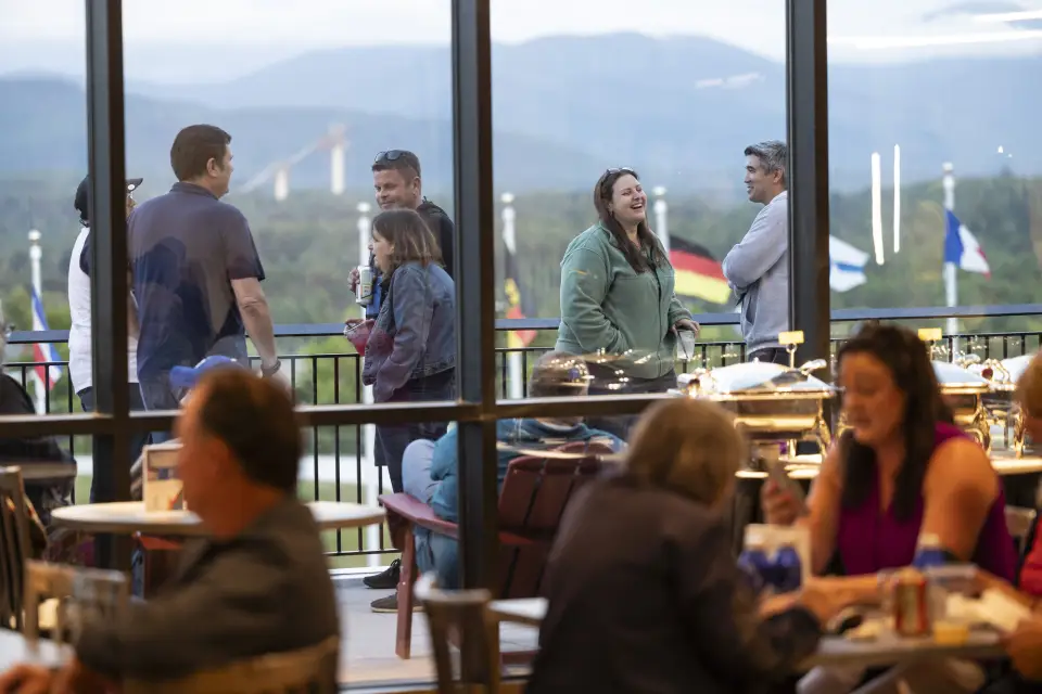 People speak to each other outside on a corporate deck.