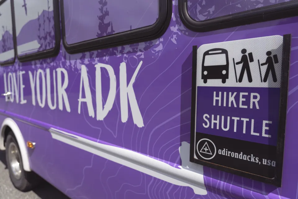 A purple shuttle with Love Your ADK on the side. 