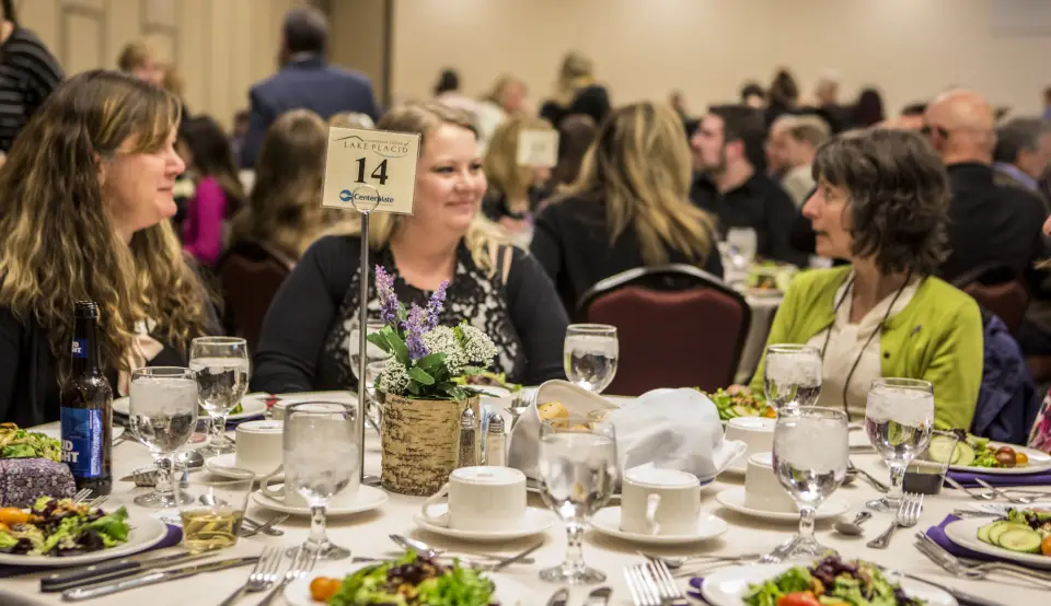 Women at a conference eat a meal together.
