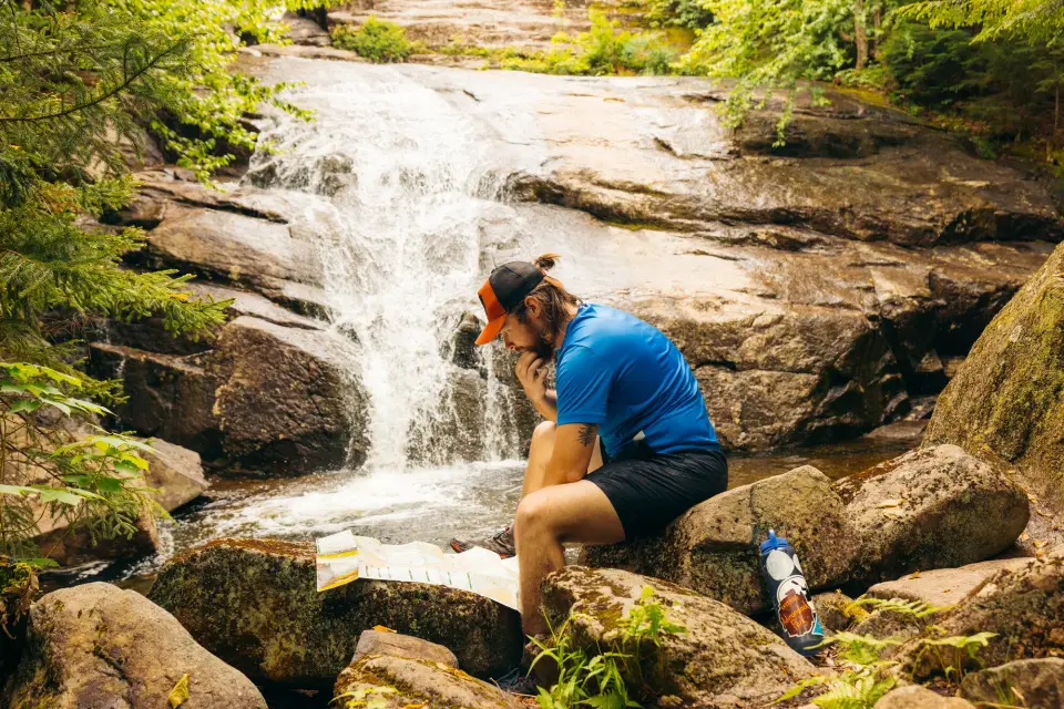 A man looking at a map with Wanika Falls behind him.