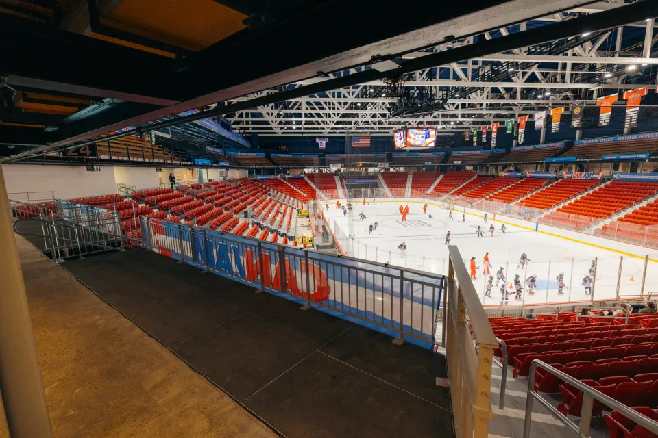 An ice hockey rink view from an accessible balcony area. 