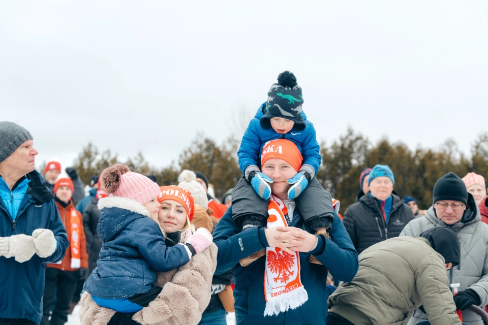 A family bundled up watching a winter event in Lake Placid.