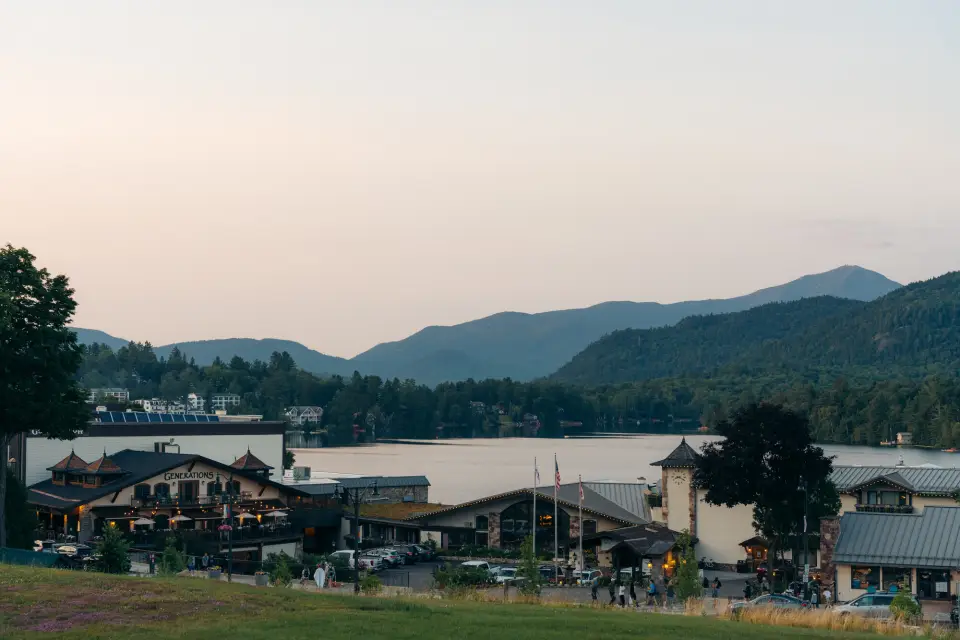 A mountain town in the evening overlooking a lake and mountains. 