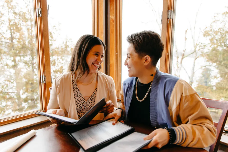 A couple sitting at a restaurant in Lake Placid, ordering from a menu.