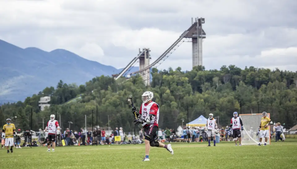 Two people play lacrosse.