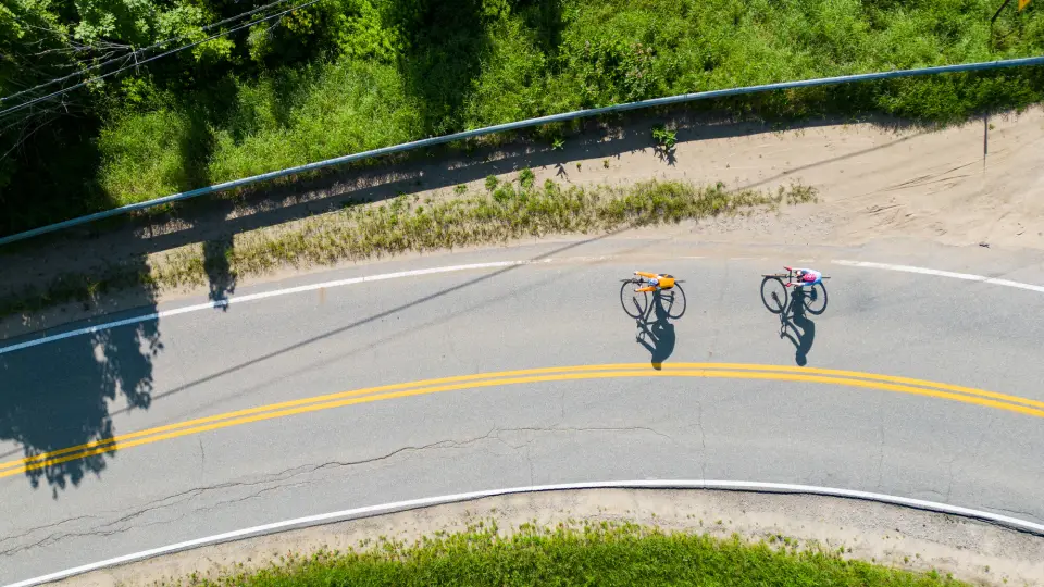 An aerial view of two bikers on a road.