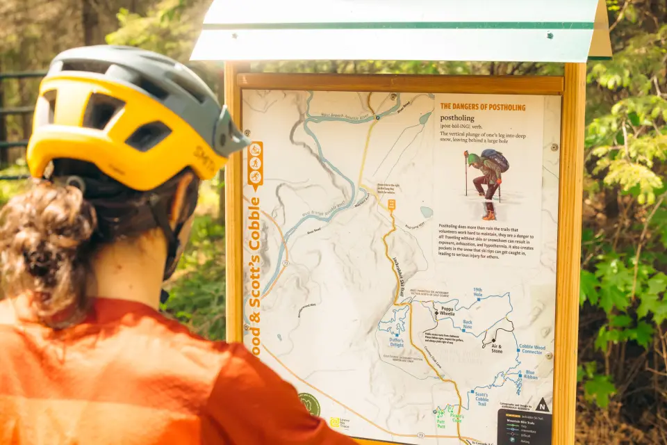A mountain biker looking at a trail map.