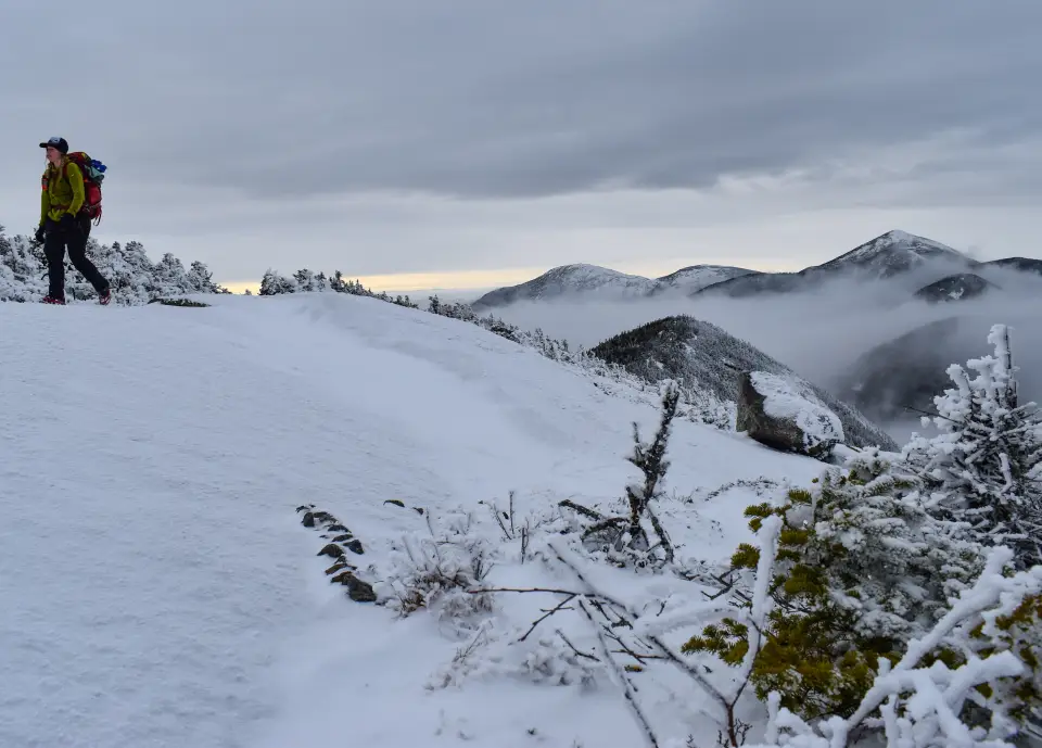 A snowshoer on a high summit ridge.