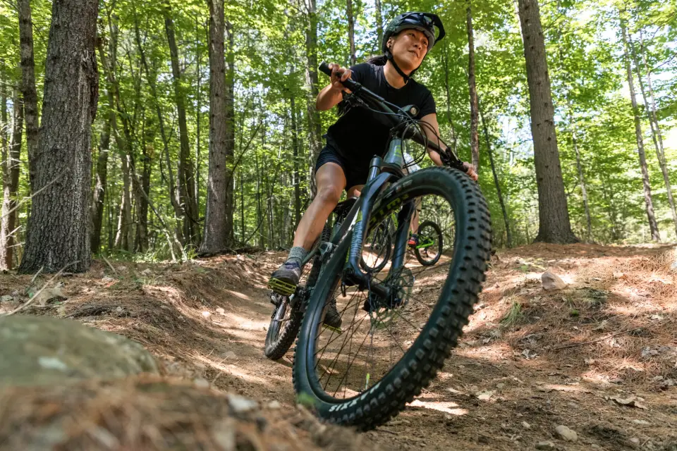 A woman rides a bike while mountain biking.