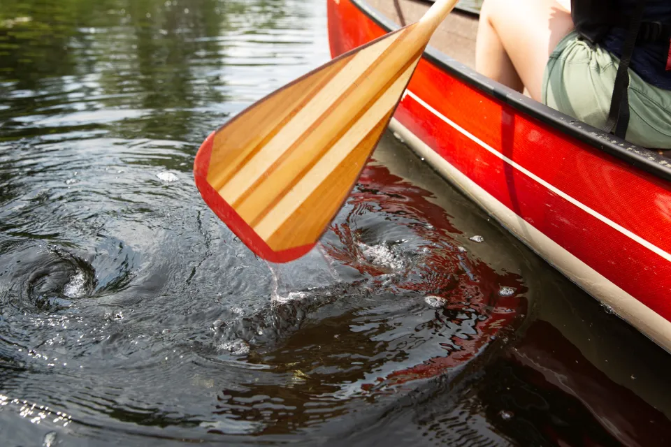 Close up of a canoe paddle in the water.