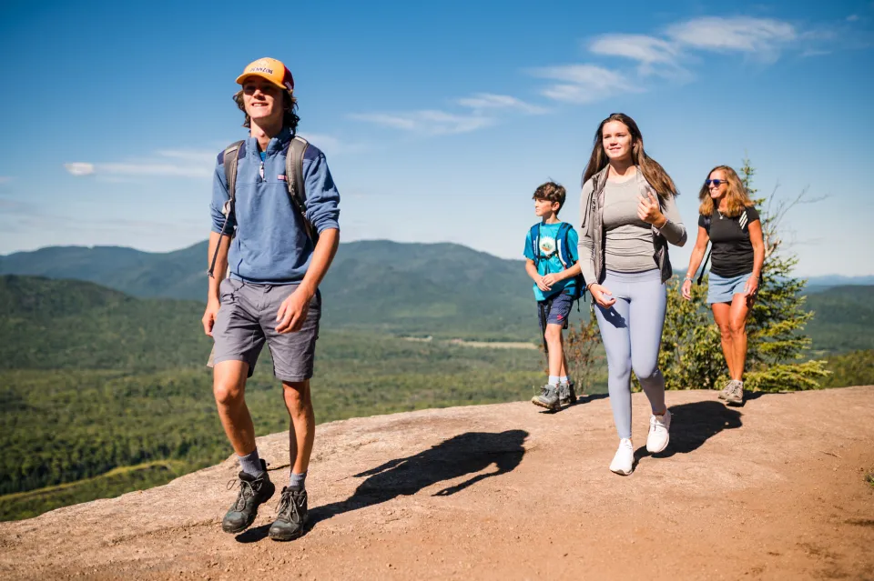 A family of four walks a rocky mountain. 