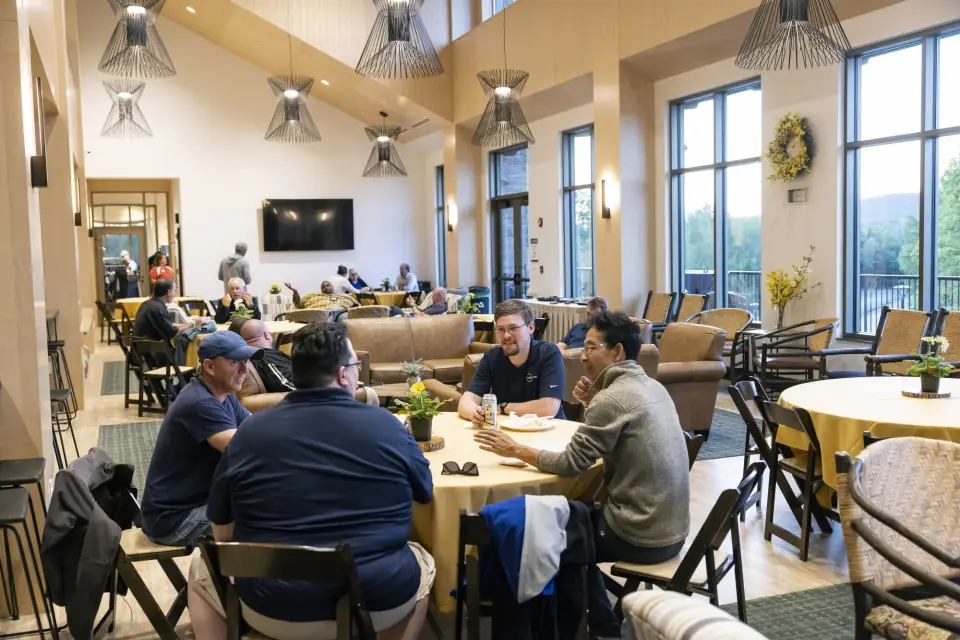 A group of men talk at a round table.