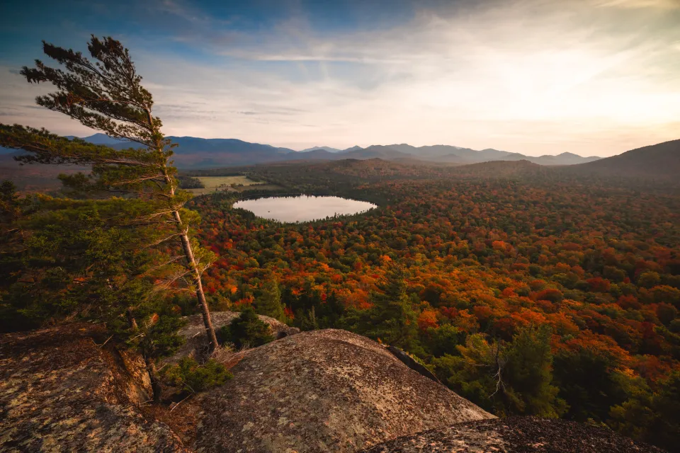 A scenic view point of surrounding foliage and lakes in the mountains. 