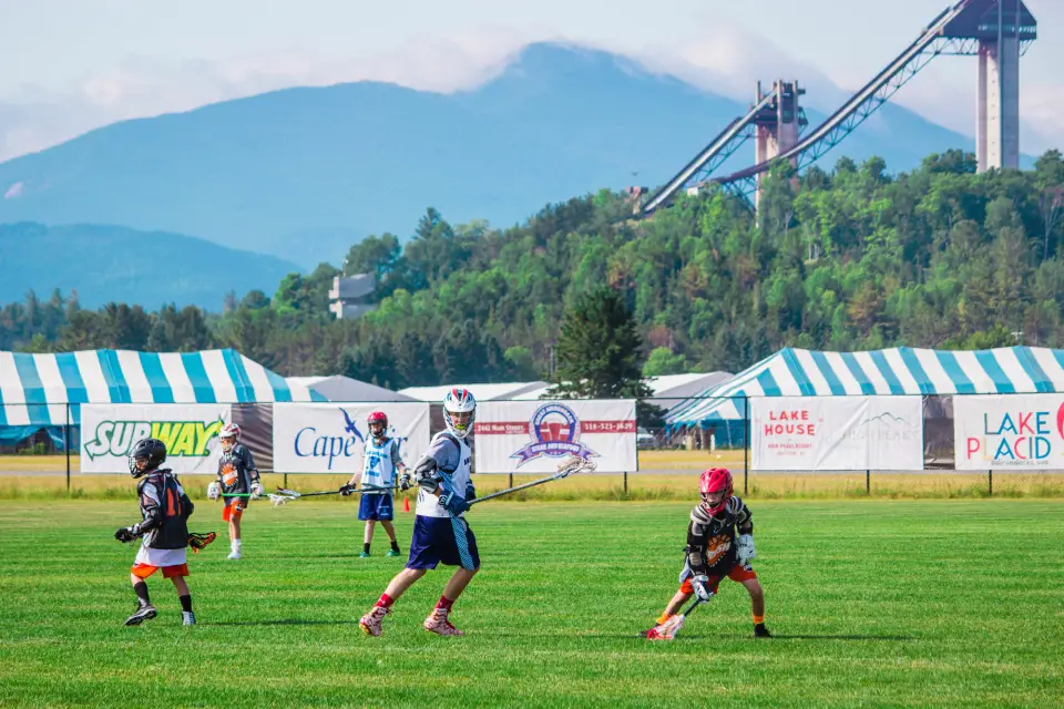 Two people play lacrosse together.