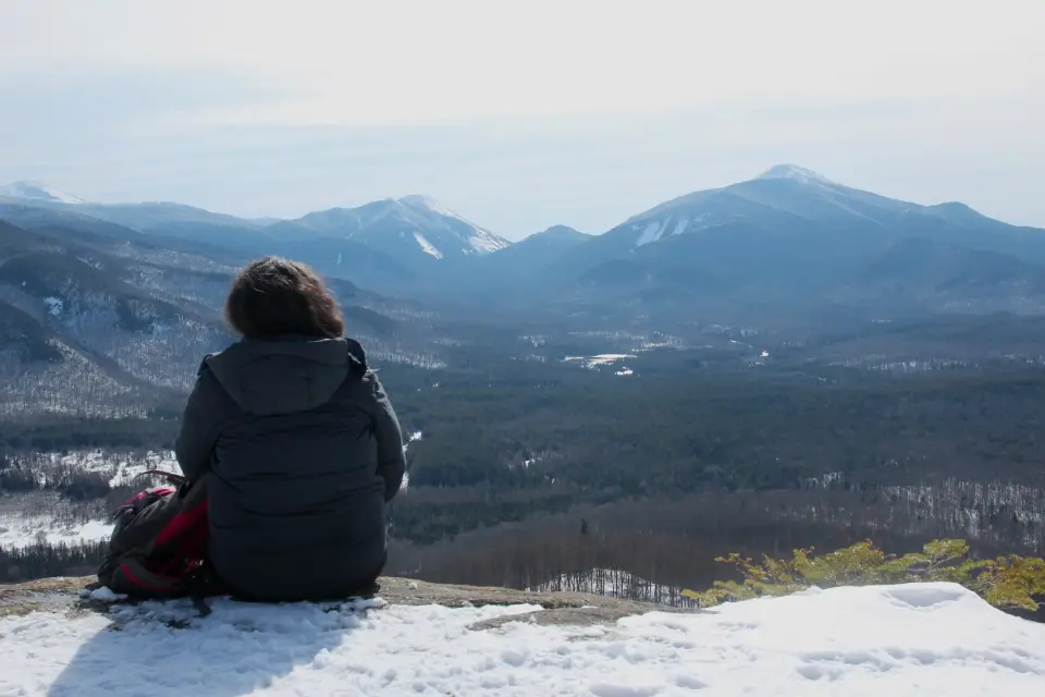 A woman looks over a mountain range.