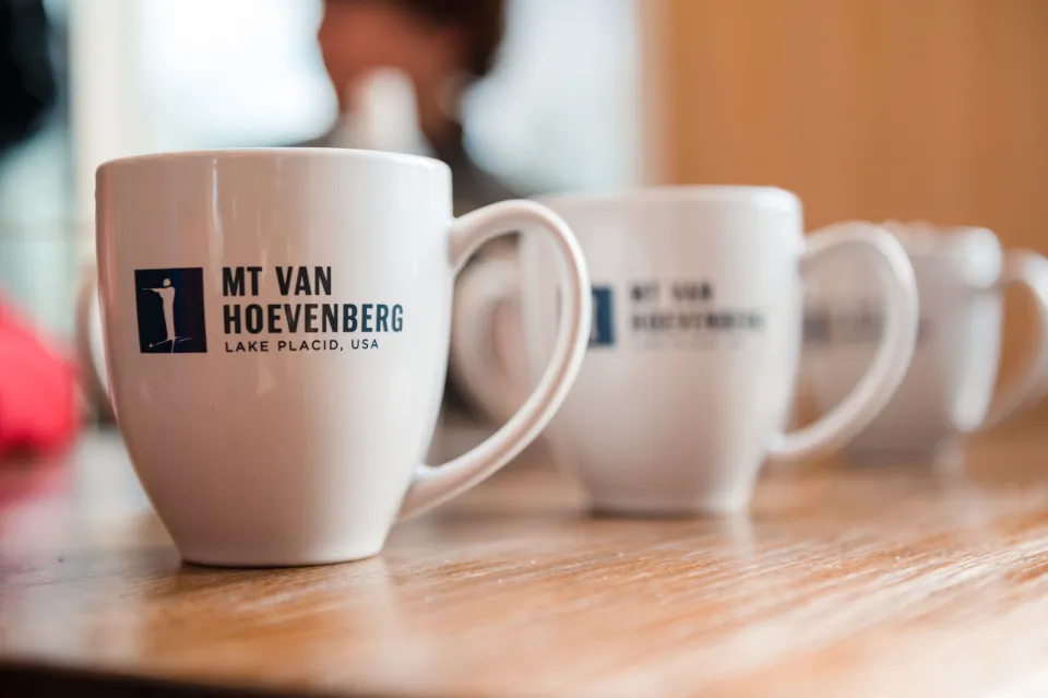 Mugs with Vanhoevenberg branding on them.
