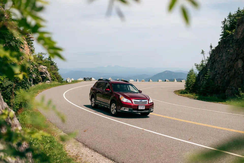 A car drives up a mountain road. 